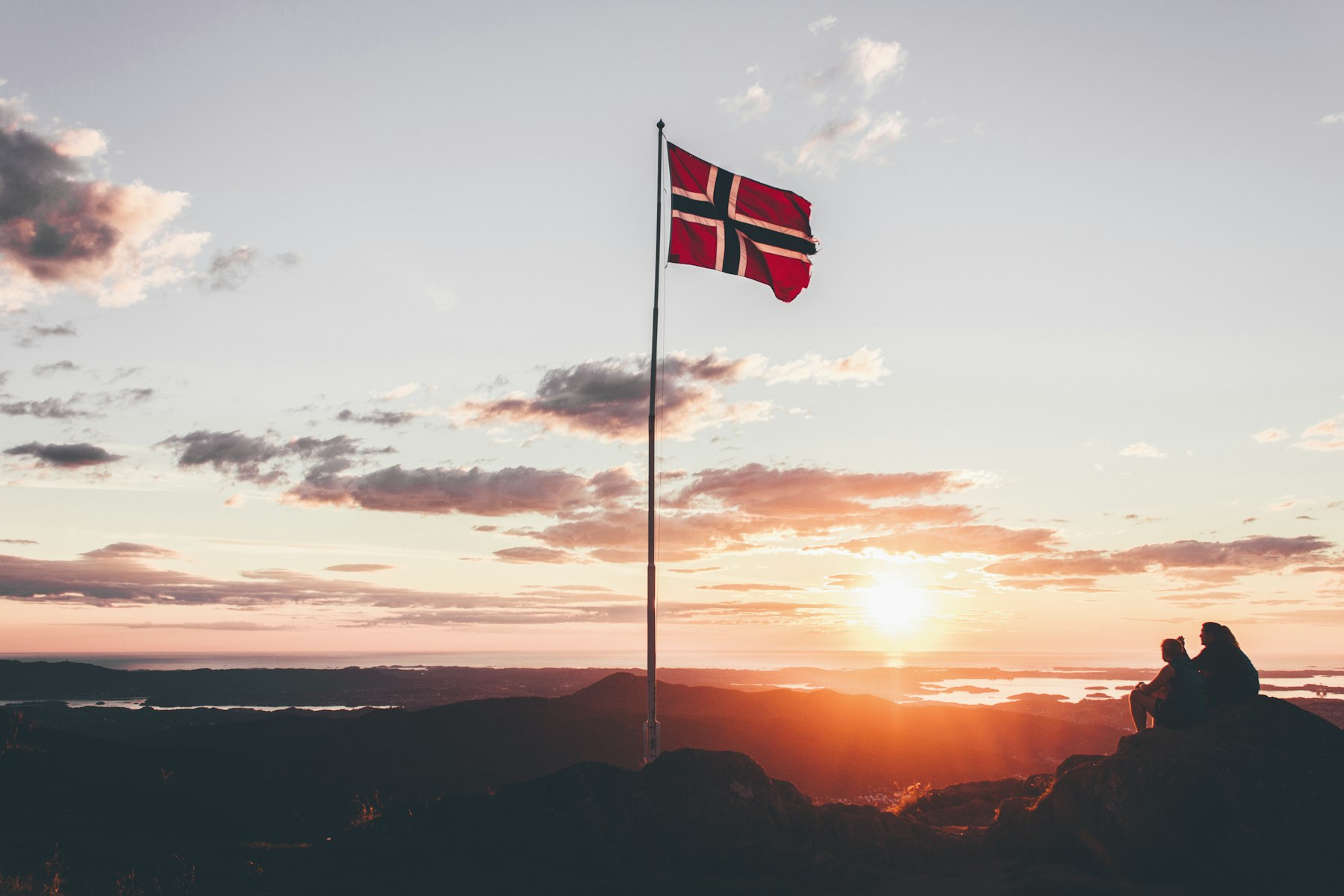 The Norwegian flag on a mountaintop at sunset