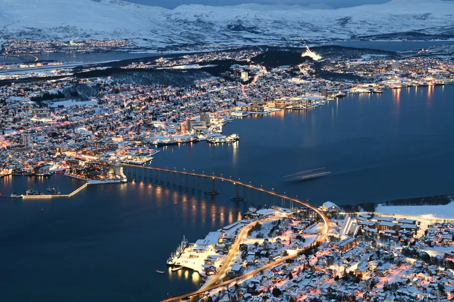 Tromsø glowing at dusk under snow-covered mountains