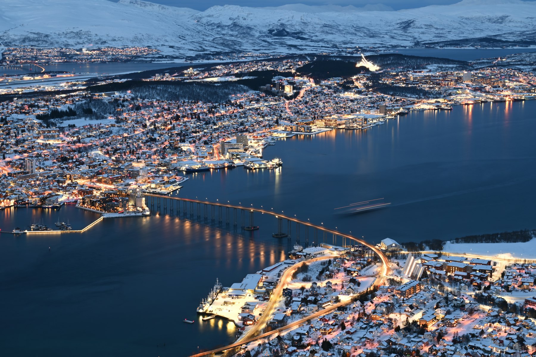 Tromsø glowing at dusk under snow-covered mountains